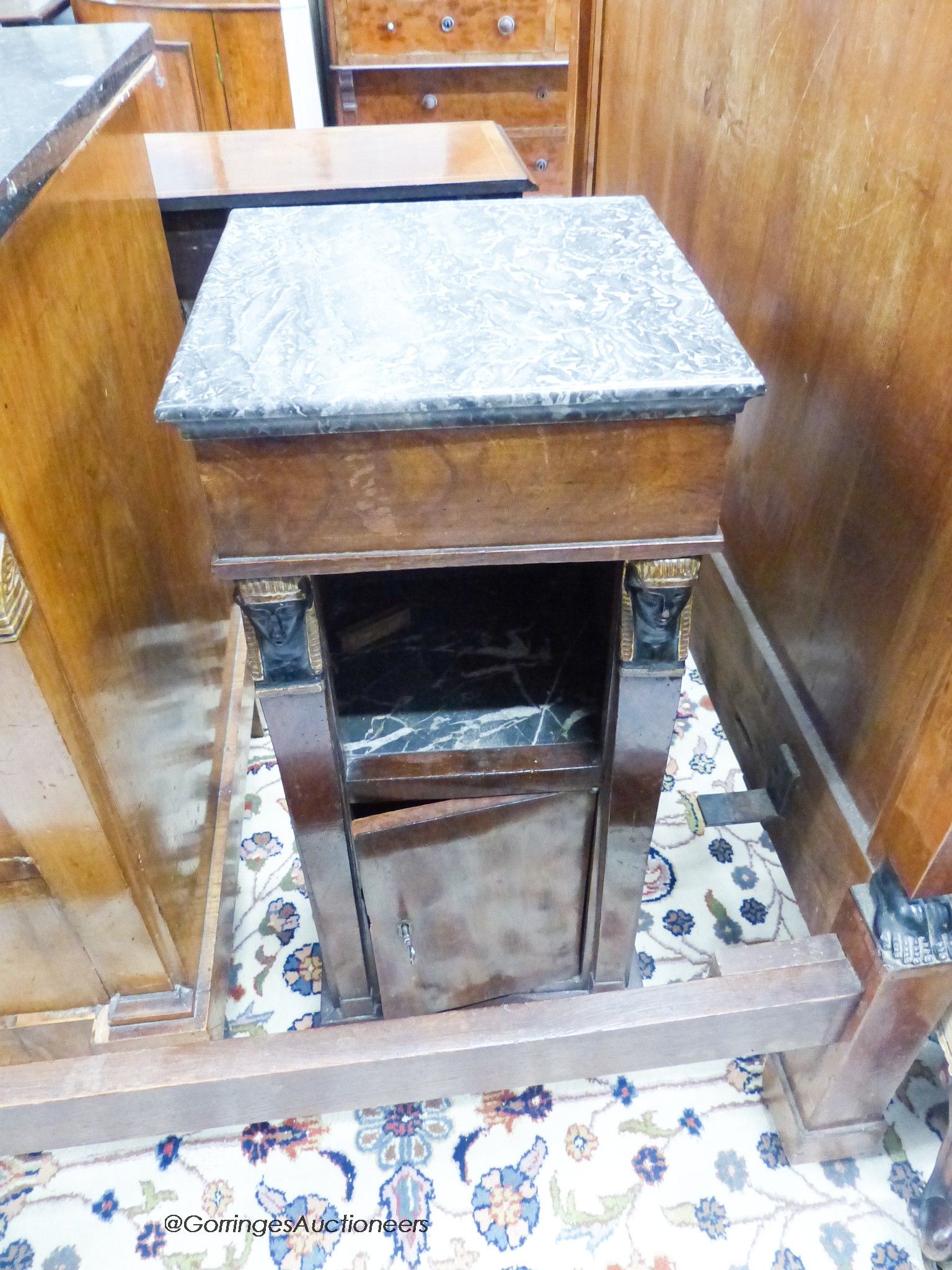 A 19th century French mahogany Egyptian taste three piece bedroom suite, comprising a three quarter size bed, a marble topped three dra